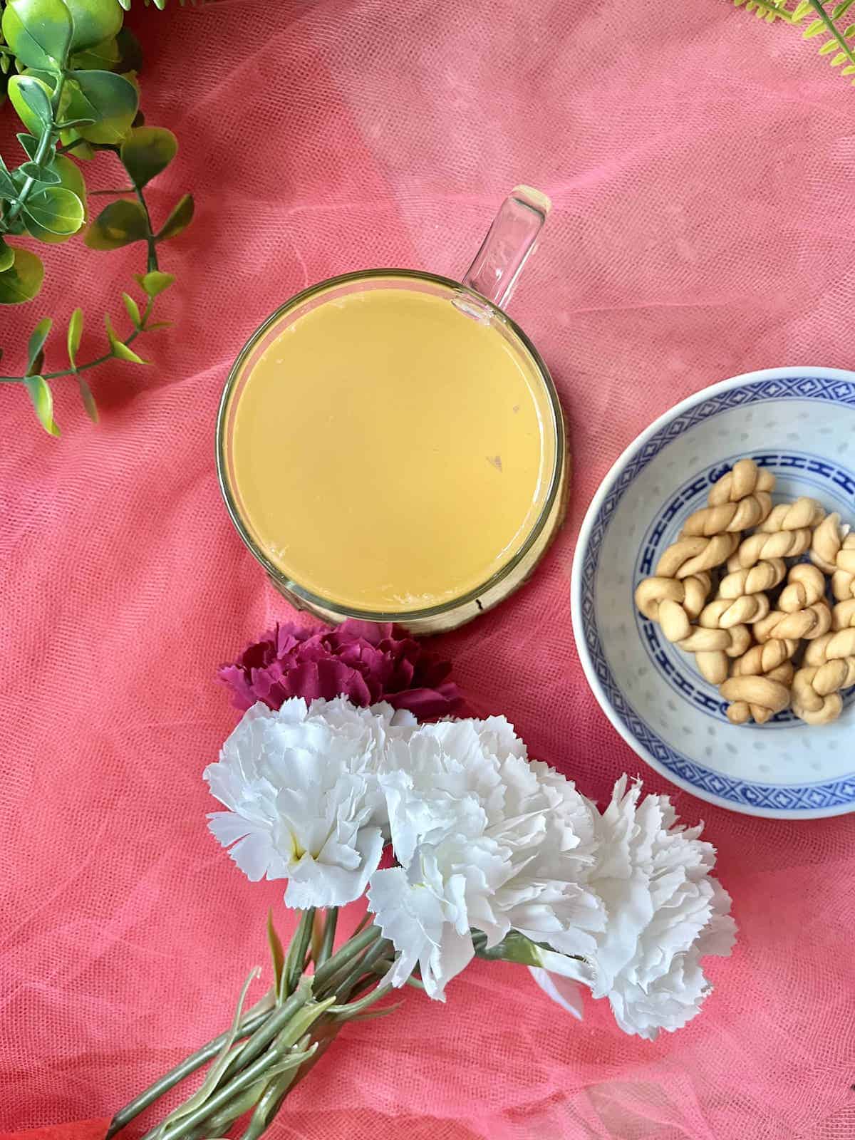 Overhead shot of a glass of Japanese citrus tea with Korean snacks next to it.