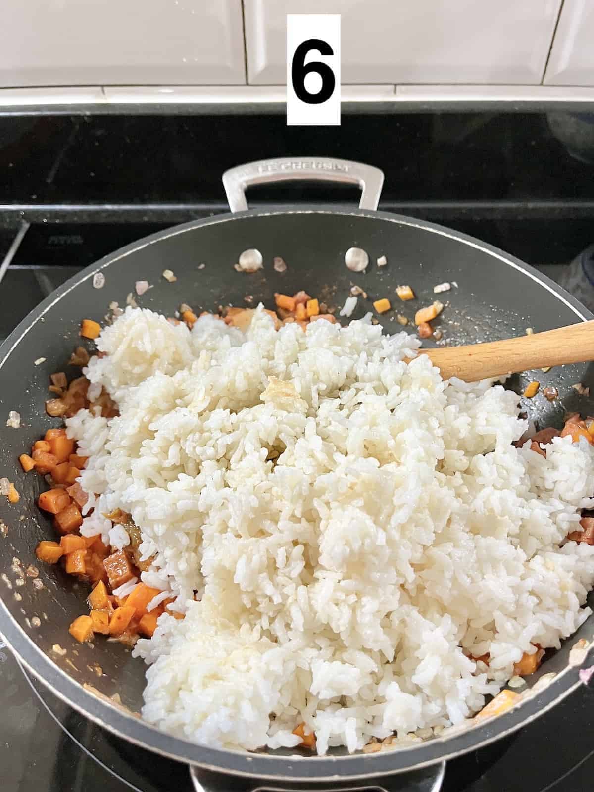 Stirring white rice into a kimchi stir fry.