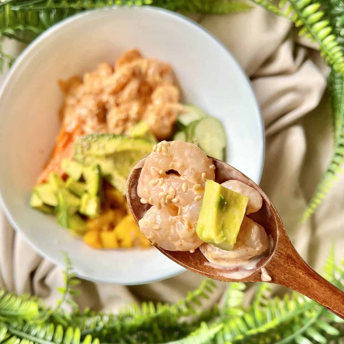 Close-up of a spoonful of shrimp rice bowl with avocado.