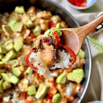 Close-up of a spoonful of baked salmon sushi rice.