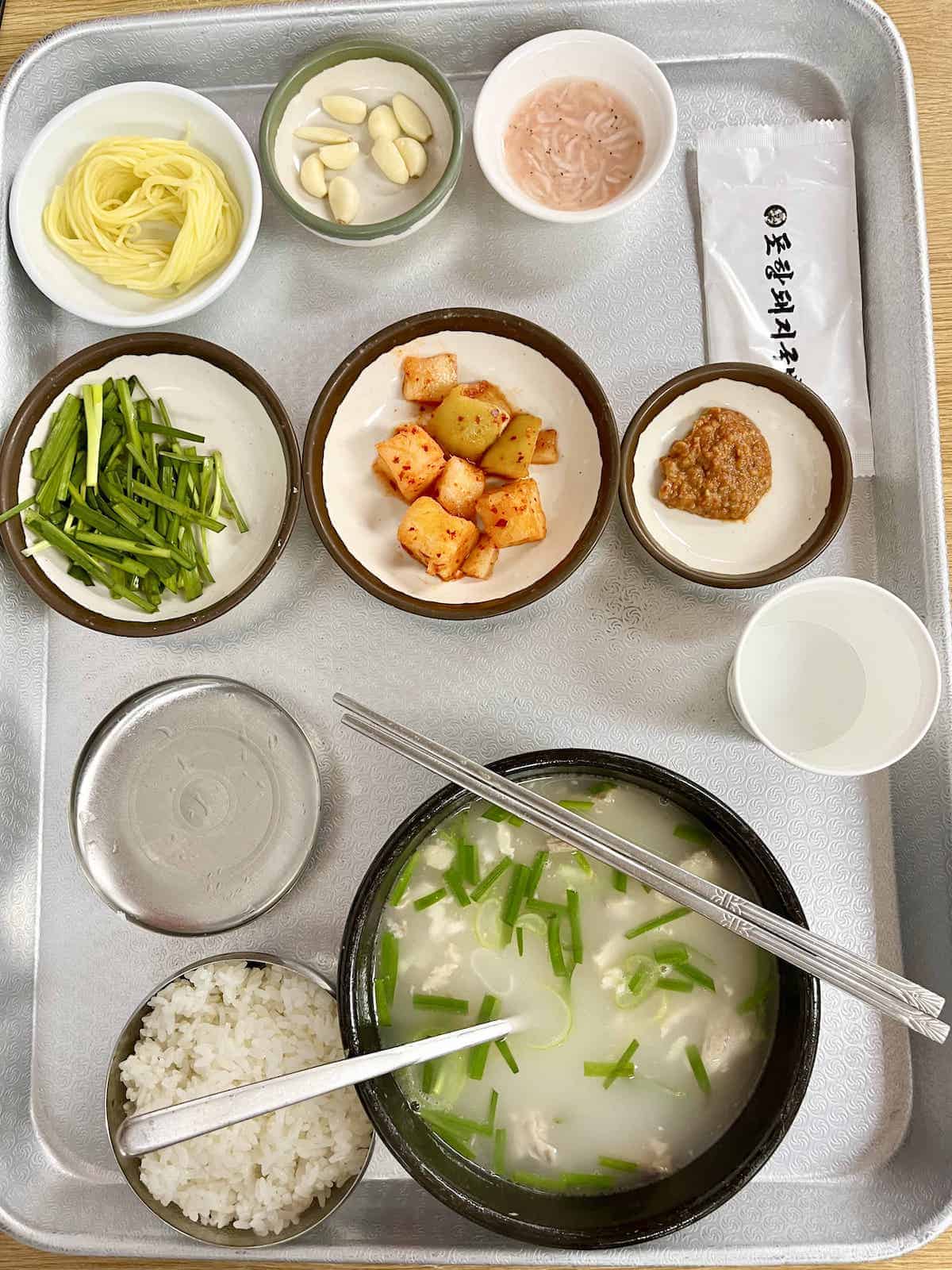 Korean radish kimchi, chives, noodles as part of a Gukbap (Pork and rice) set meal.