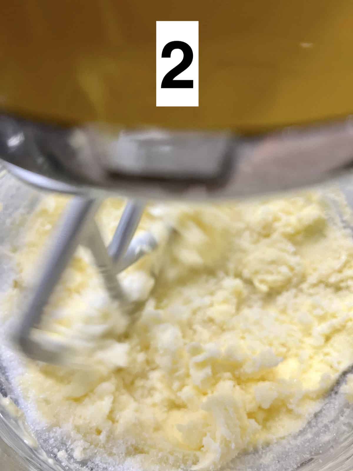 Butter and sugar being creamed in a stand mixer.