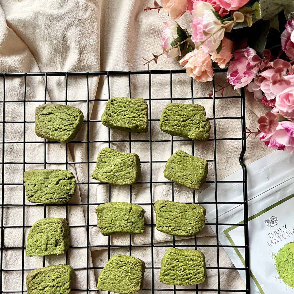 12 bright green matcha cookies on a wire rack.