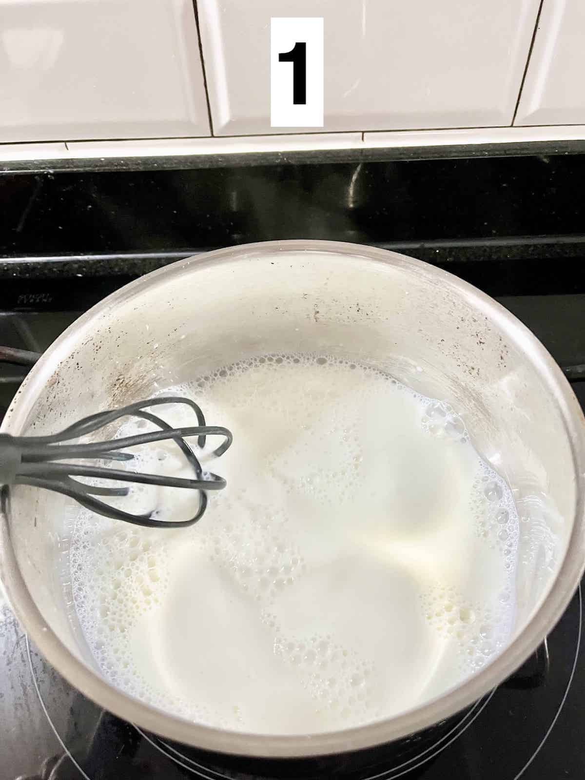 Whisking hot milk to create foam.