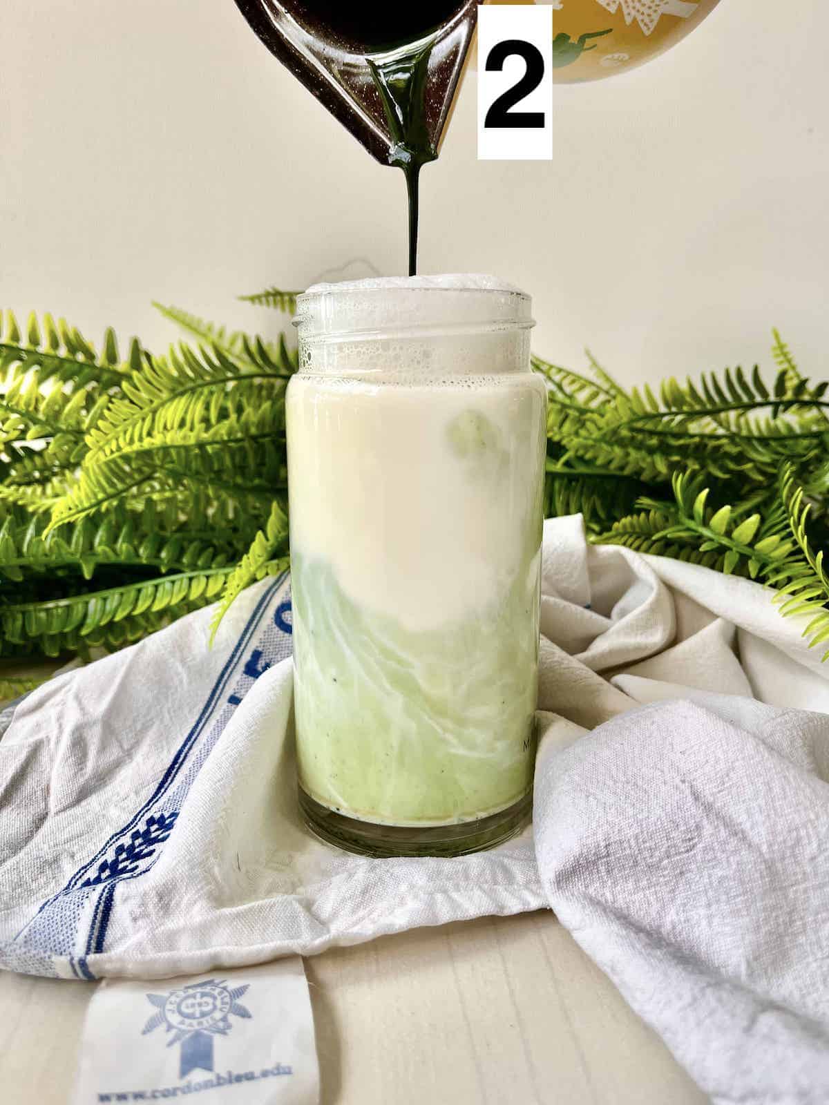 Pouring matcha concentrate into milk.