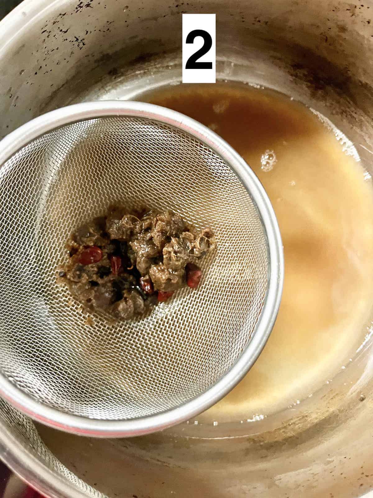 Straining tamarind juice through a fine sieve.