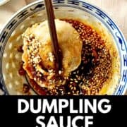 A Chinese dumpling dipped into sesame black vinegar dumpling sauce.