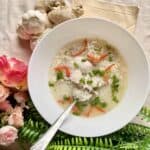 A bowl of chicken rice soup with chicken thigh fillet.