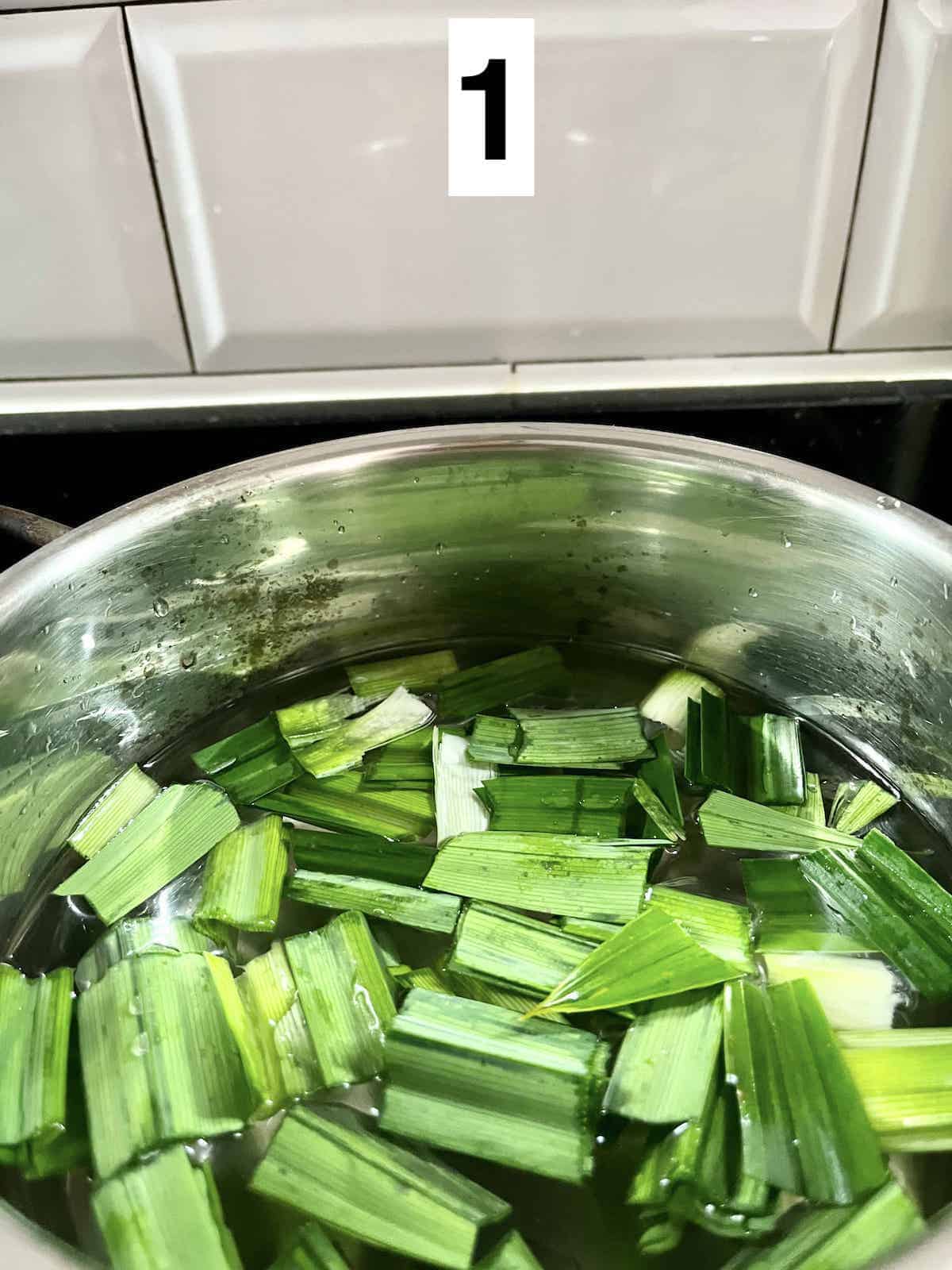 Cut Pandan Leaves floating in water in a pot.