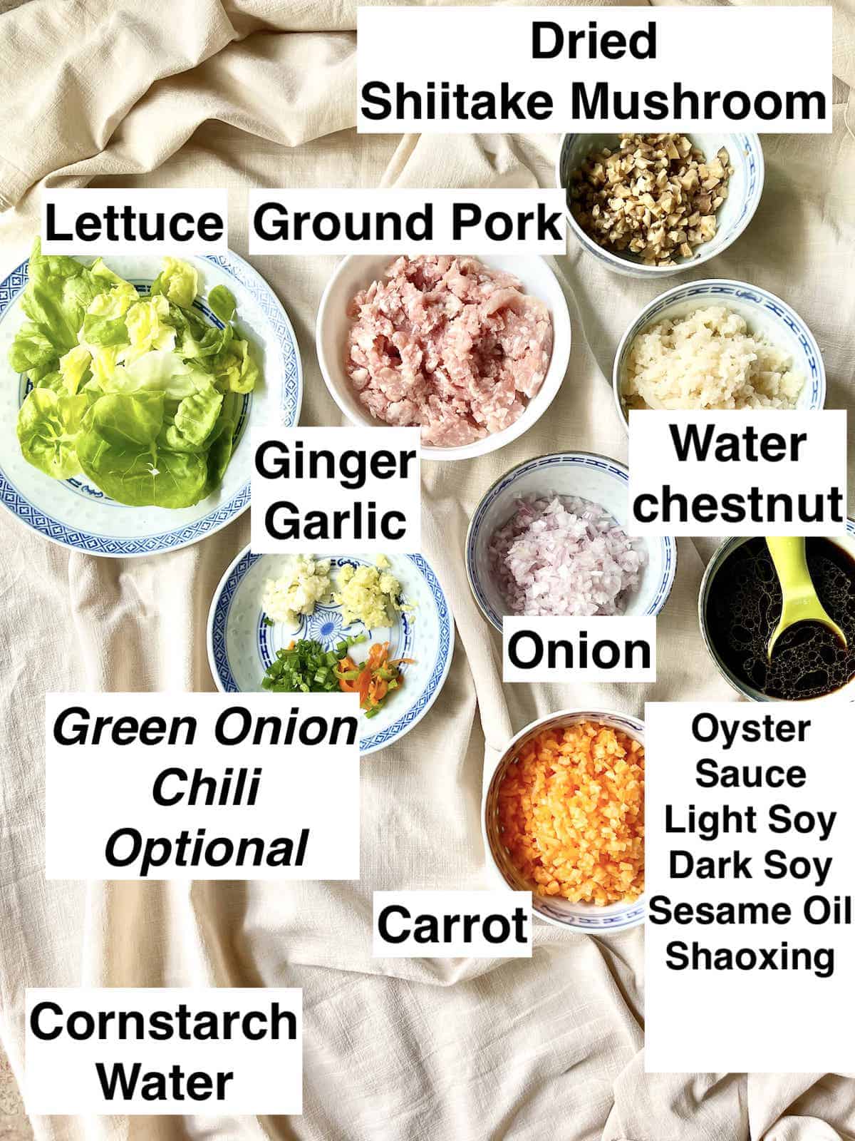 The ingredients for Chinese pork lettuce wraps on a table cloth.