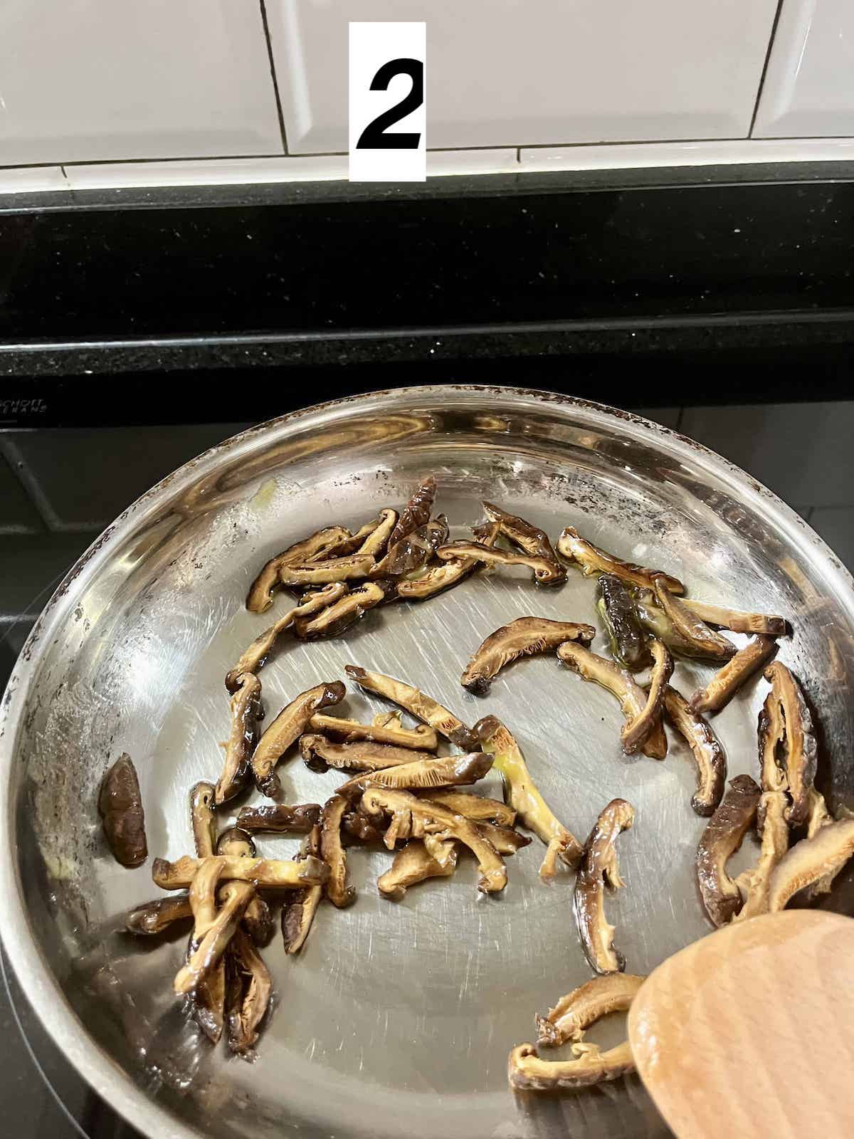 Sauteeing mushrooms in a pan.