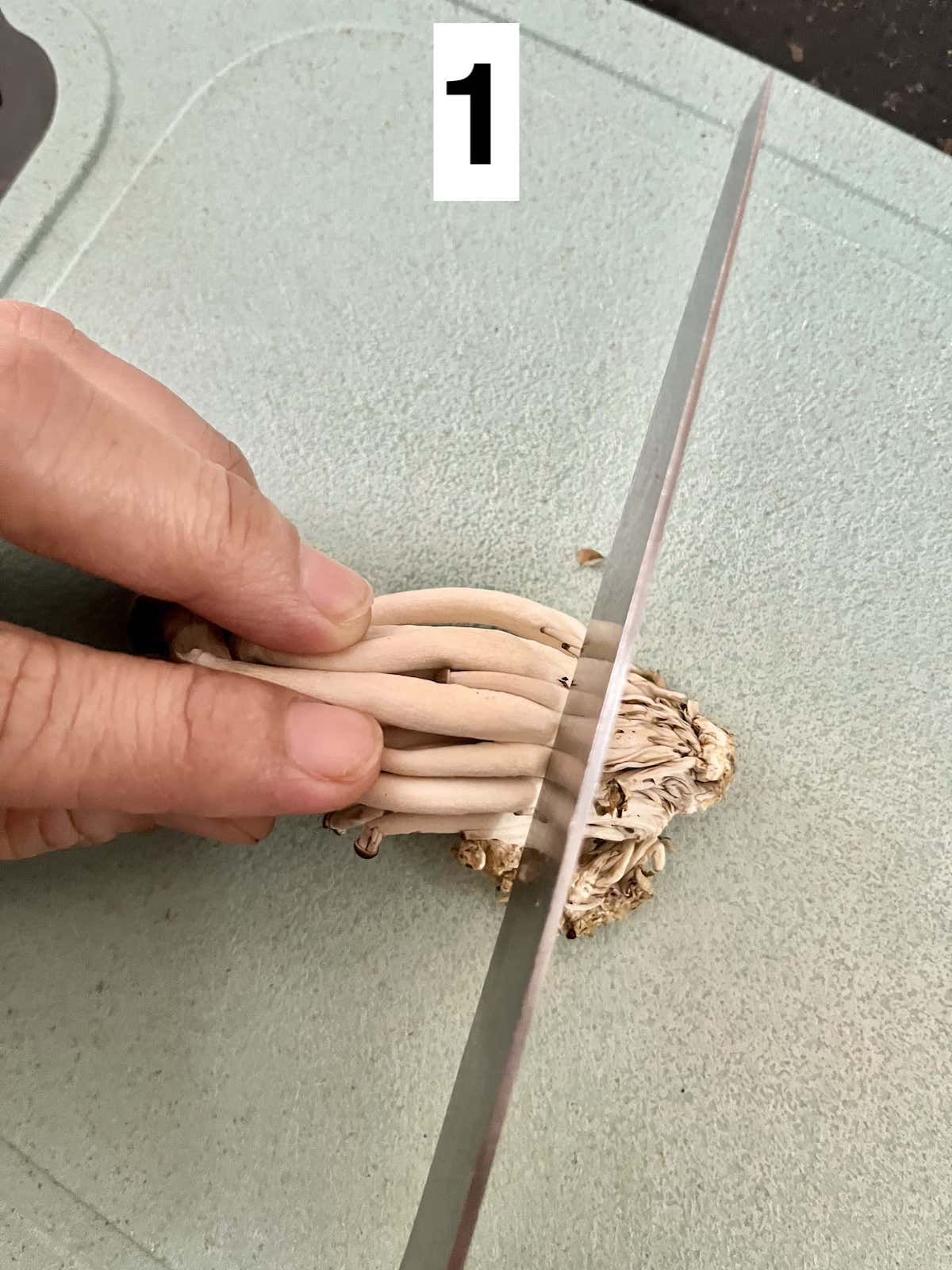 Slicing off the base of shimeji mushrooms.