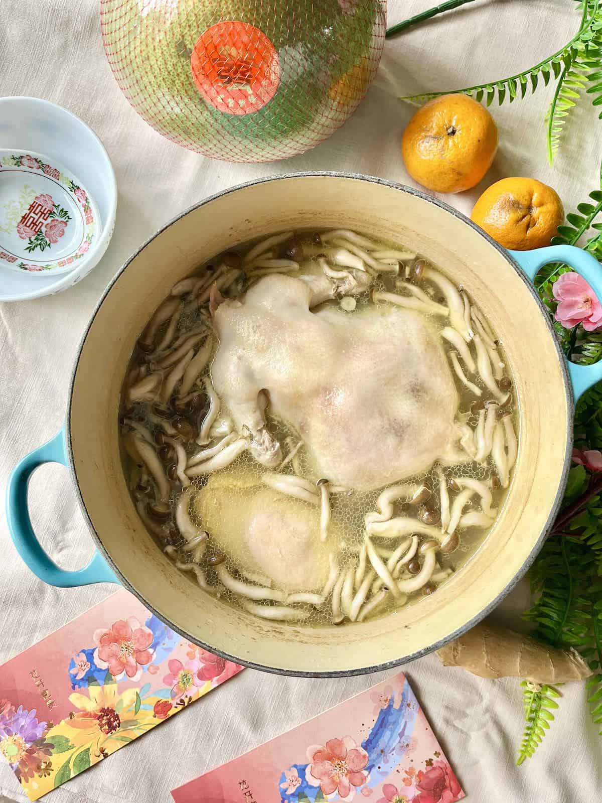 A pot full of chicken soup, abalone, and mushrooms.