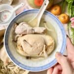 Holding up a bowl of chicken soup with a giant abalone.