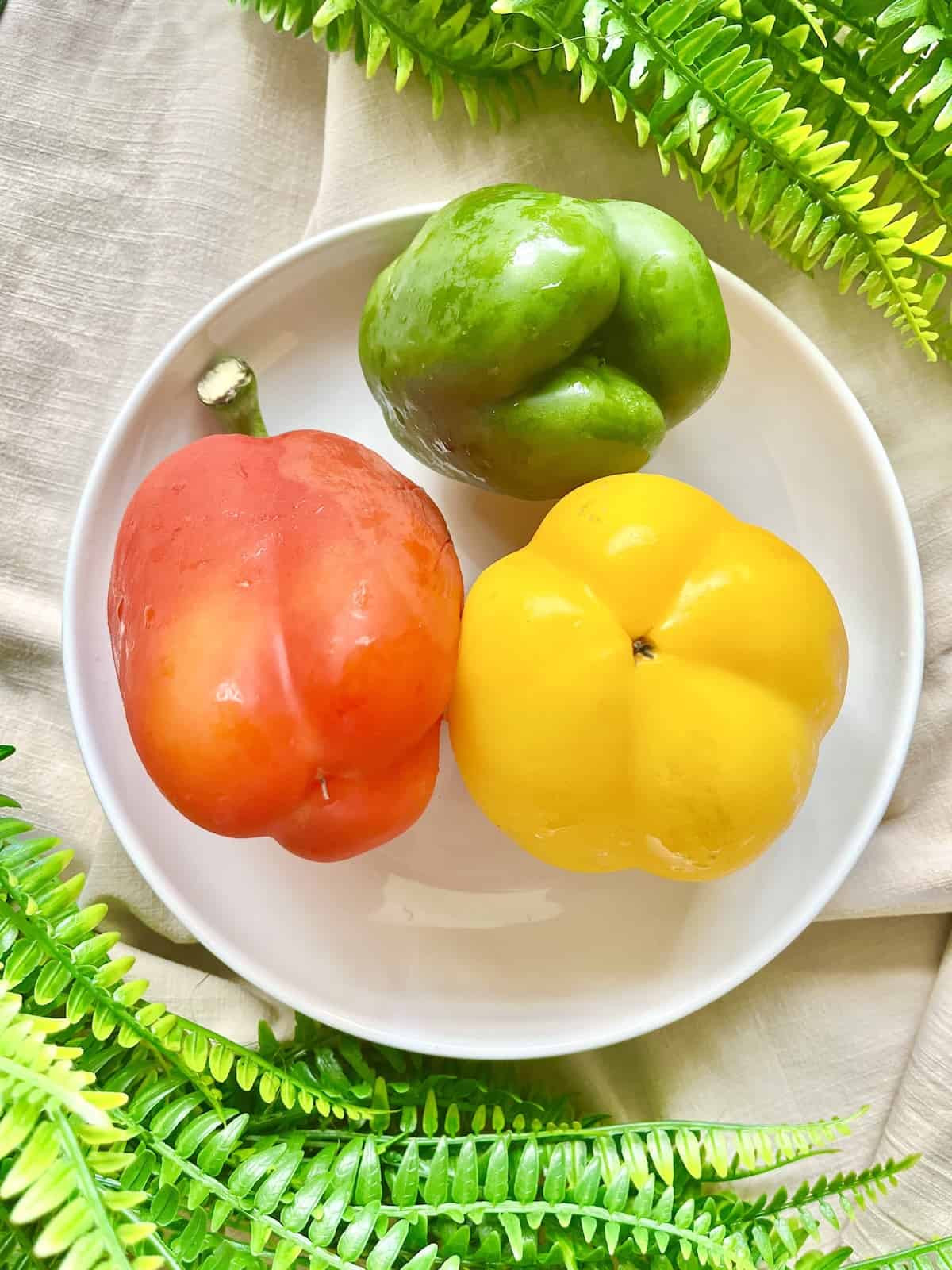 2 male and 1 female capsicum on a white plate.