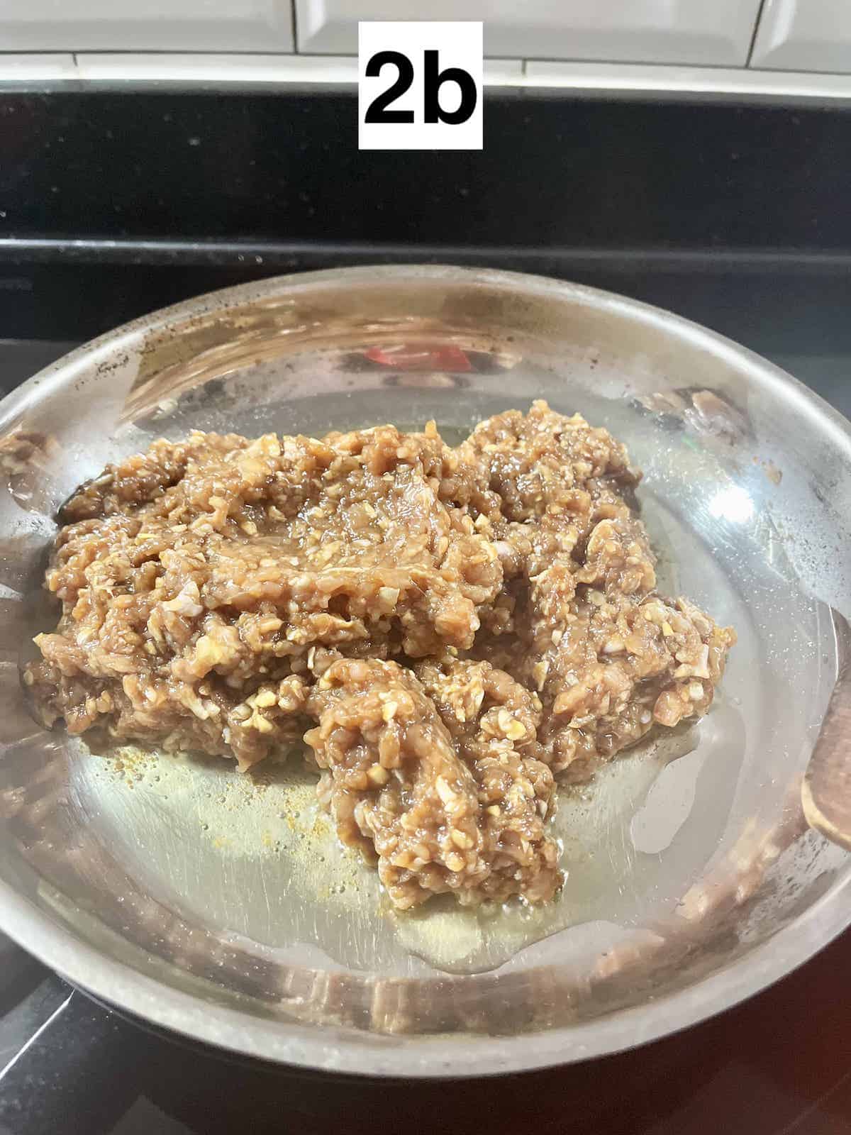 Ground chicken in a silver pan.