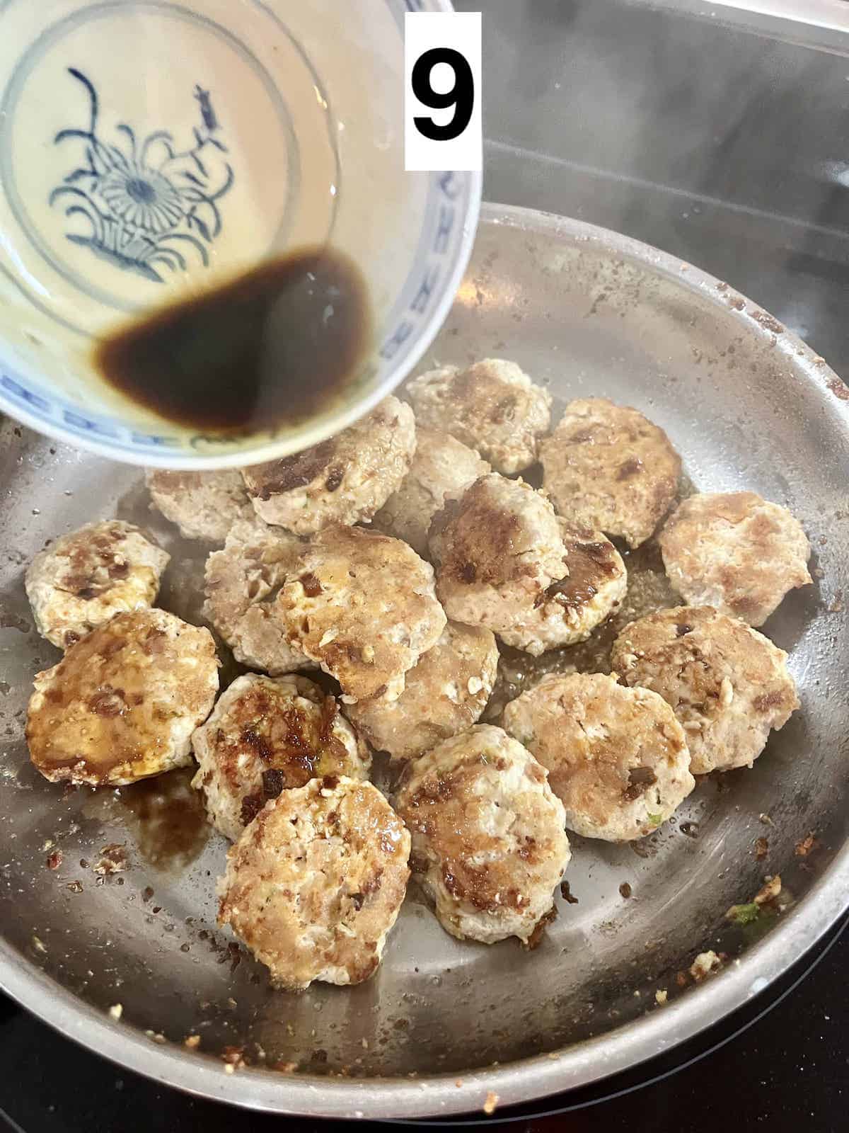 Pouring homemade Japanese teriyaki sauce into a silver pan full of meatballs.