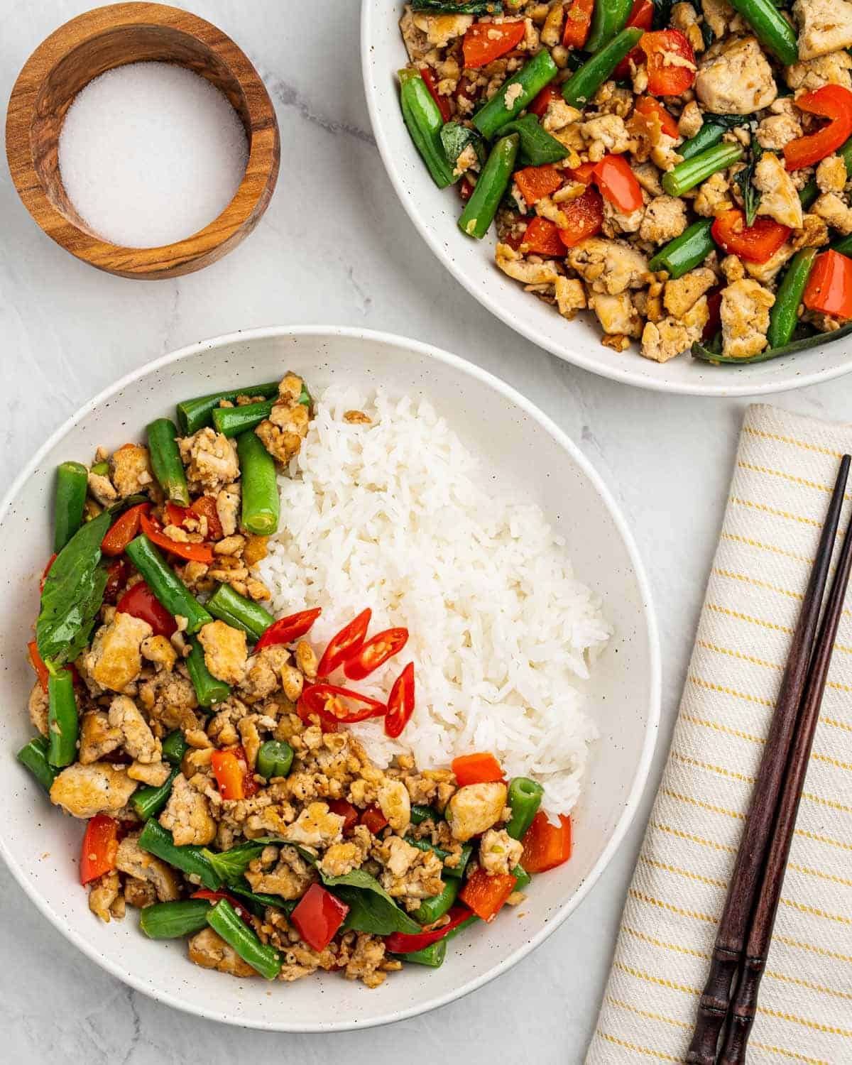 2 plates of stir fried Thai Basil tofu with white rice.