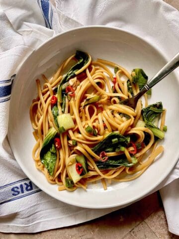 Chow Mein Spaghetti Noodles with Bok Choy on a white plate.