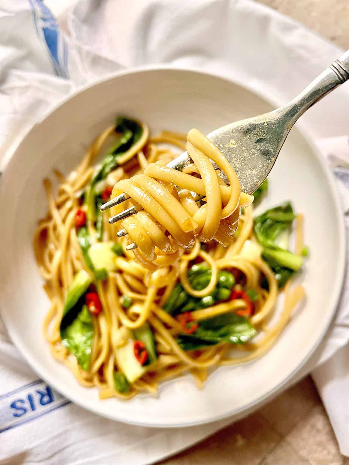 Close-up of a forkful of chow mein spaghetti noodles.