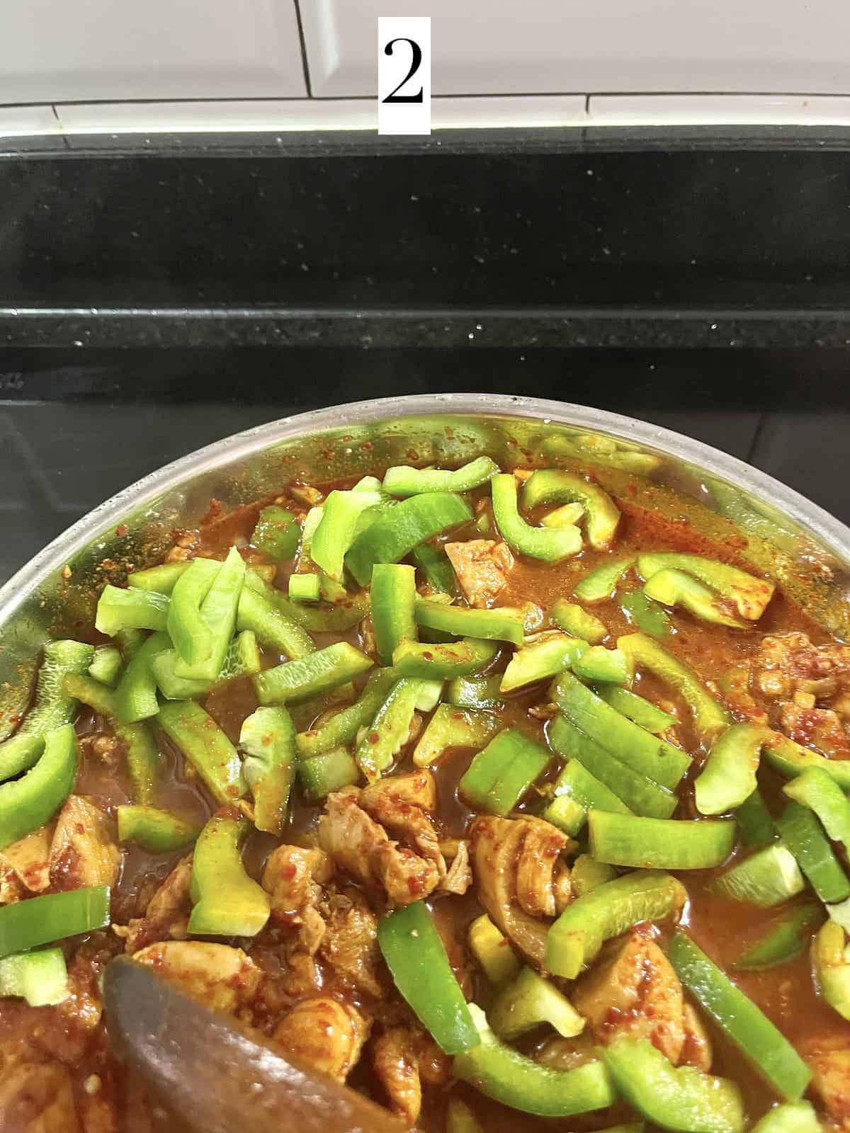 Stir frying gochujang chicken thighs and bell peppers.