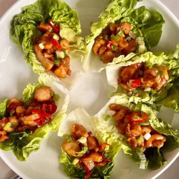6 Korean Chicken lettuce wraps on a white plate.