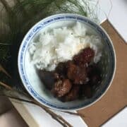A bowl of Filipino braised adobo pork belly and white rice.