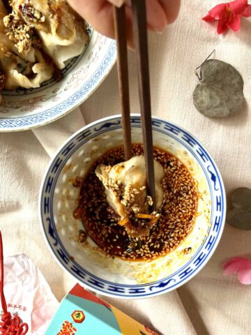Dipping Chinese dumpling into sauce.