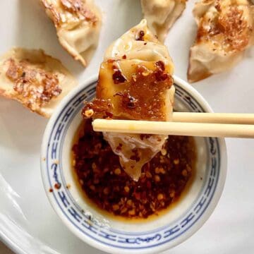 Dipping a pan-fried dumpling into spicy Japanese sauce.