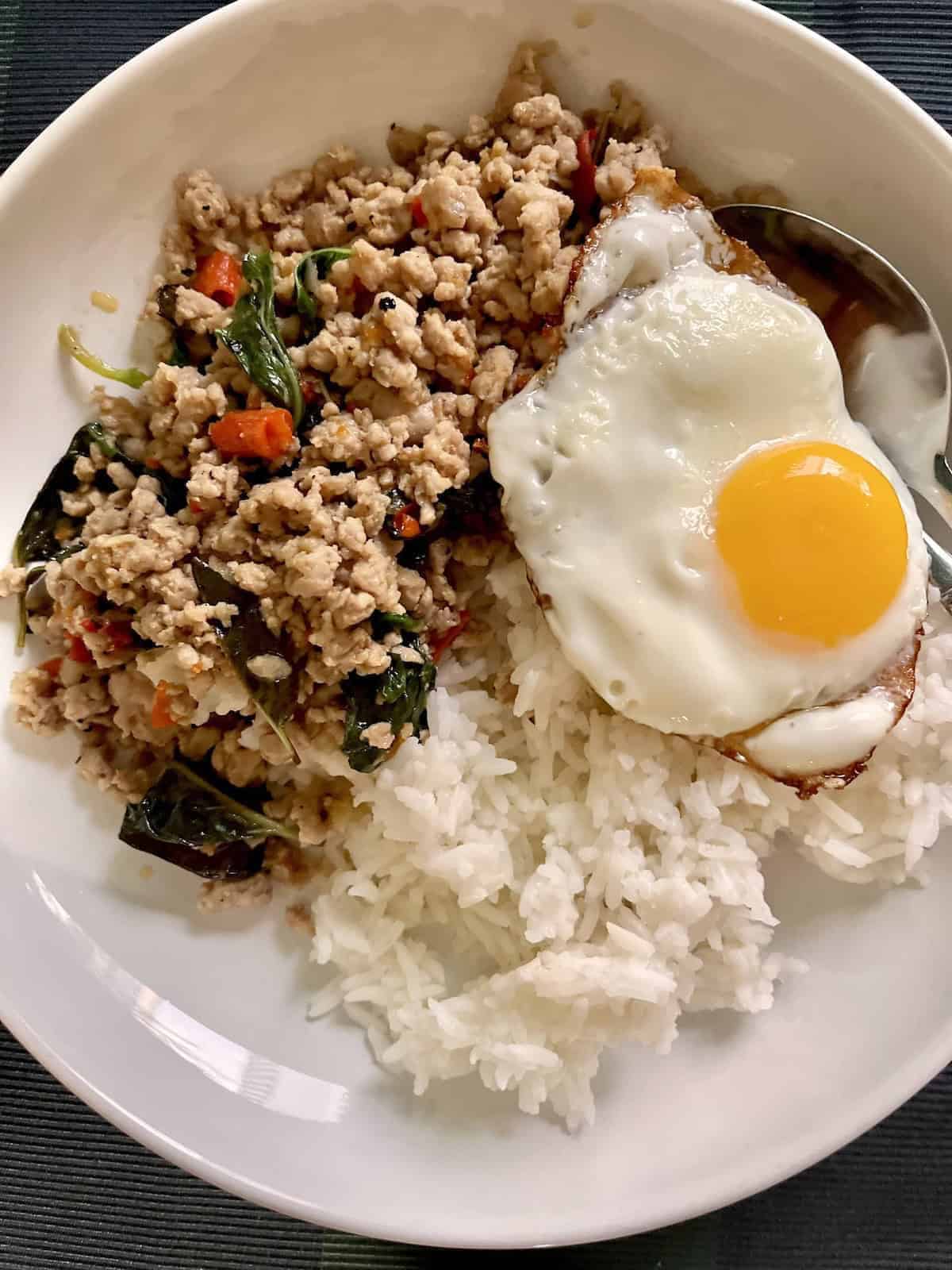 A plate of authentic Thai Basil Pork Mince with rice and fried egg.
