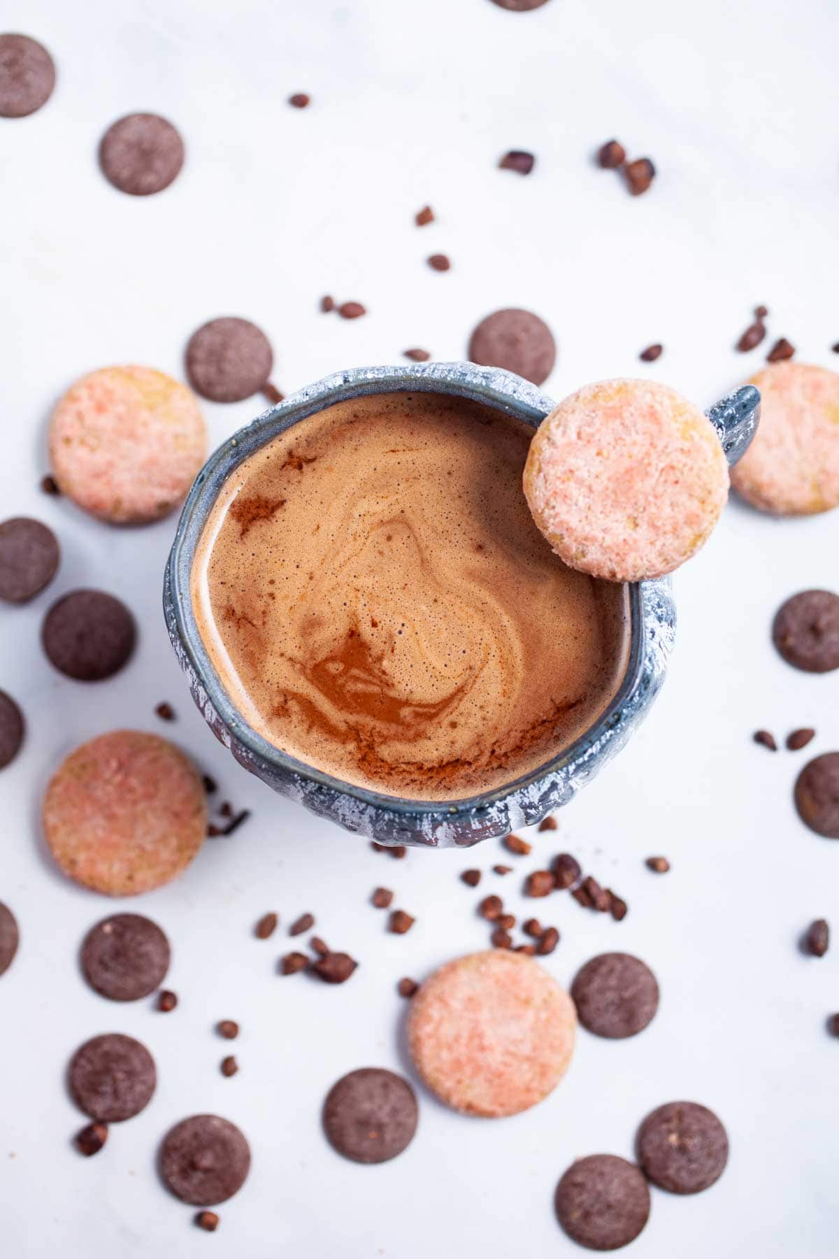 Overhead shot of mug of hot chocolate with chocolate around it.