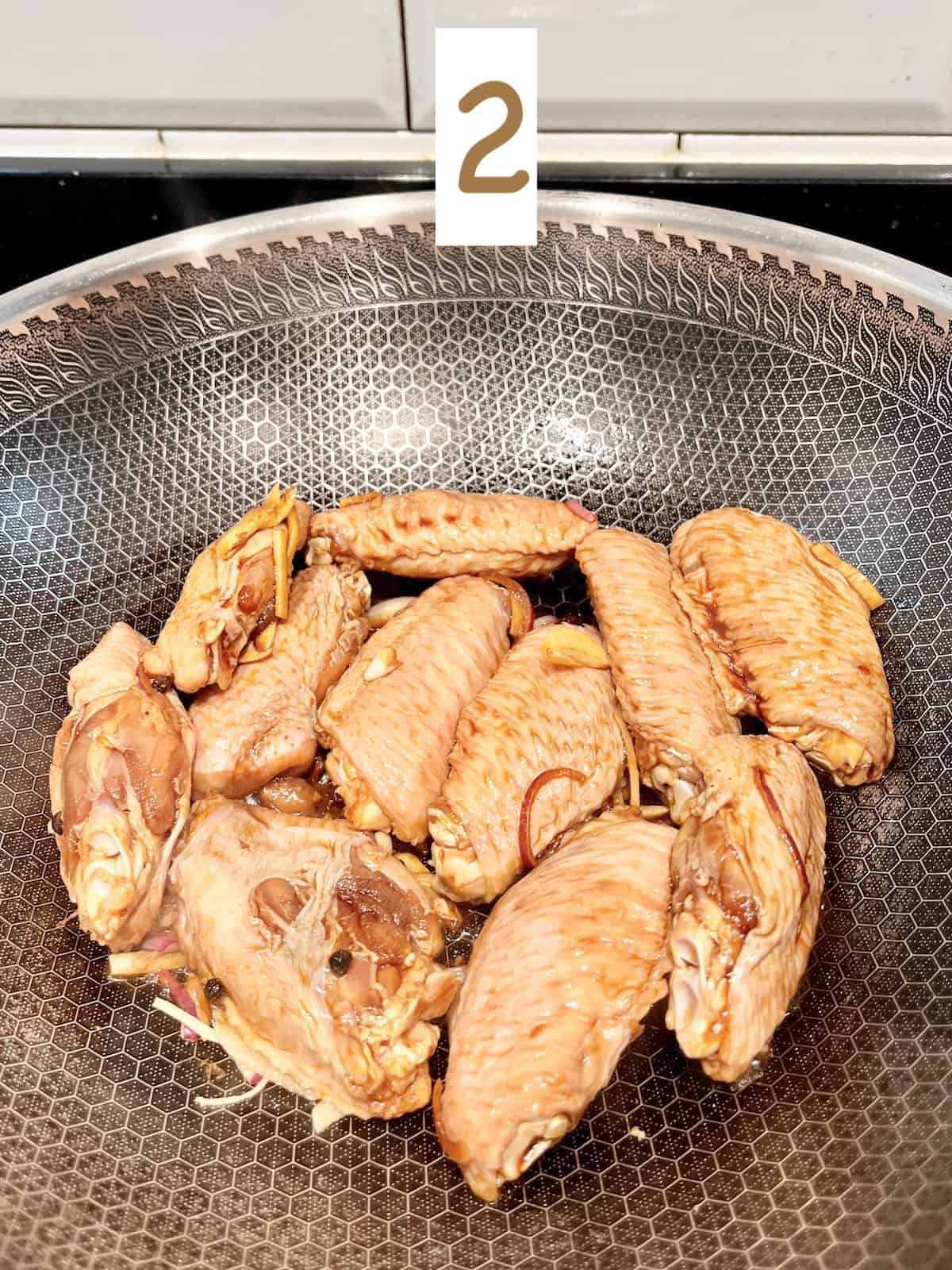 Browning chicken wings in a pan.