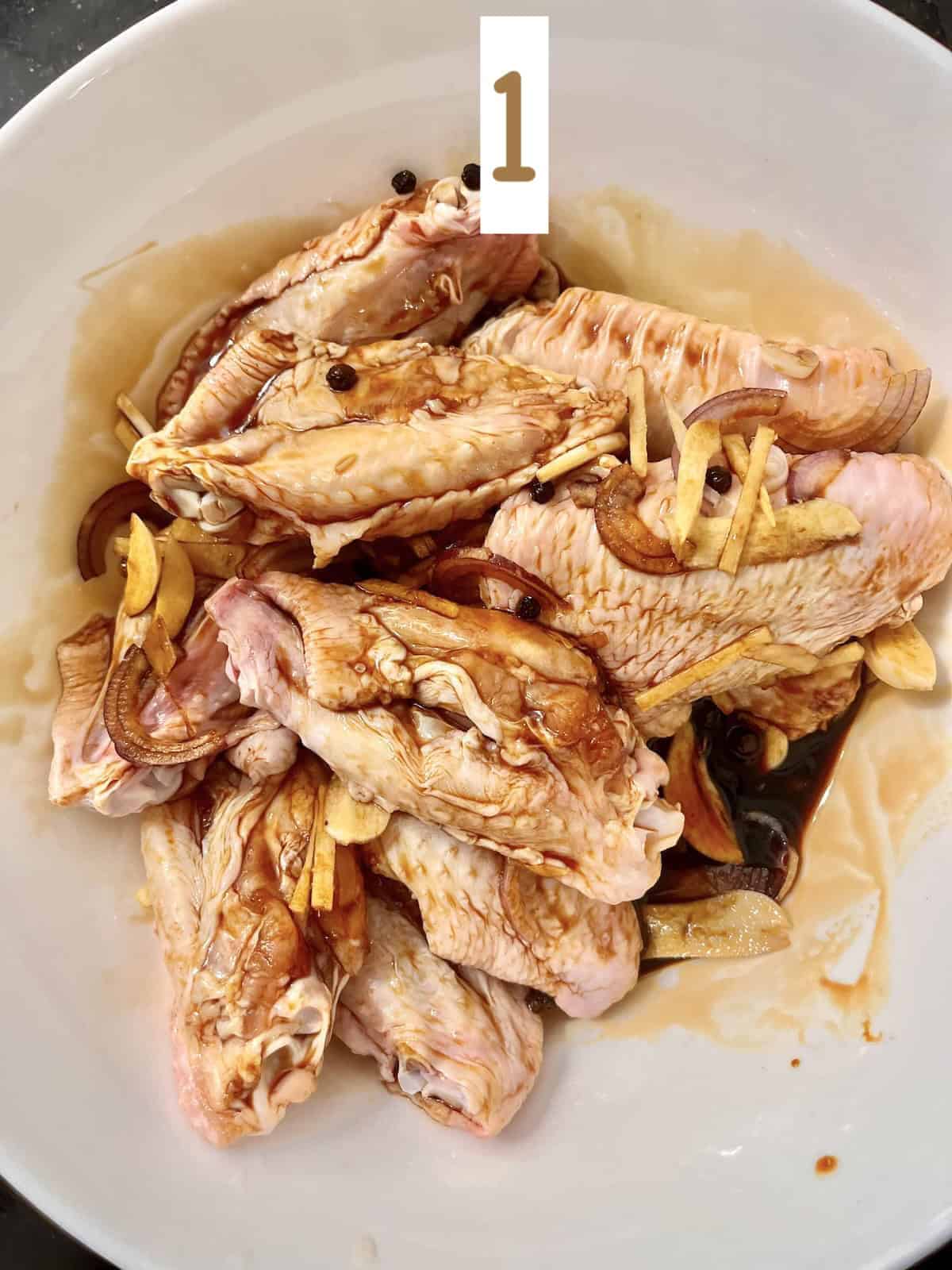Marinating chicken wings in adobo sauce.
