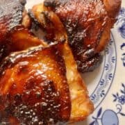 3 pieces of char siu chicken on a blue and white plate.