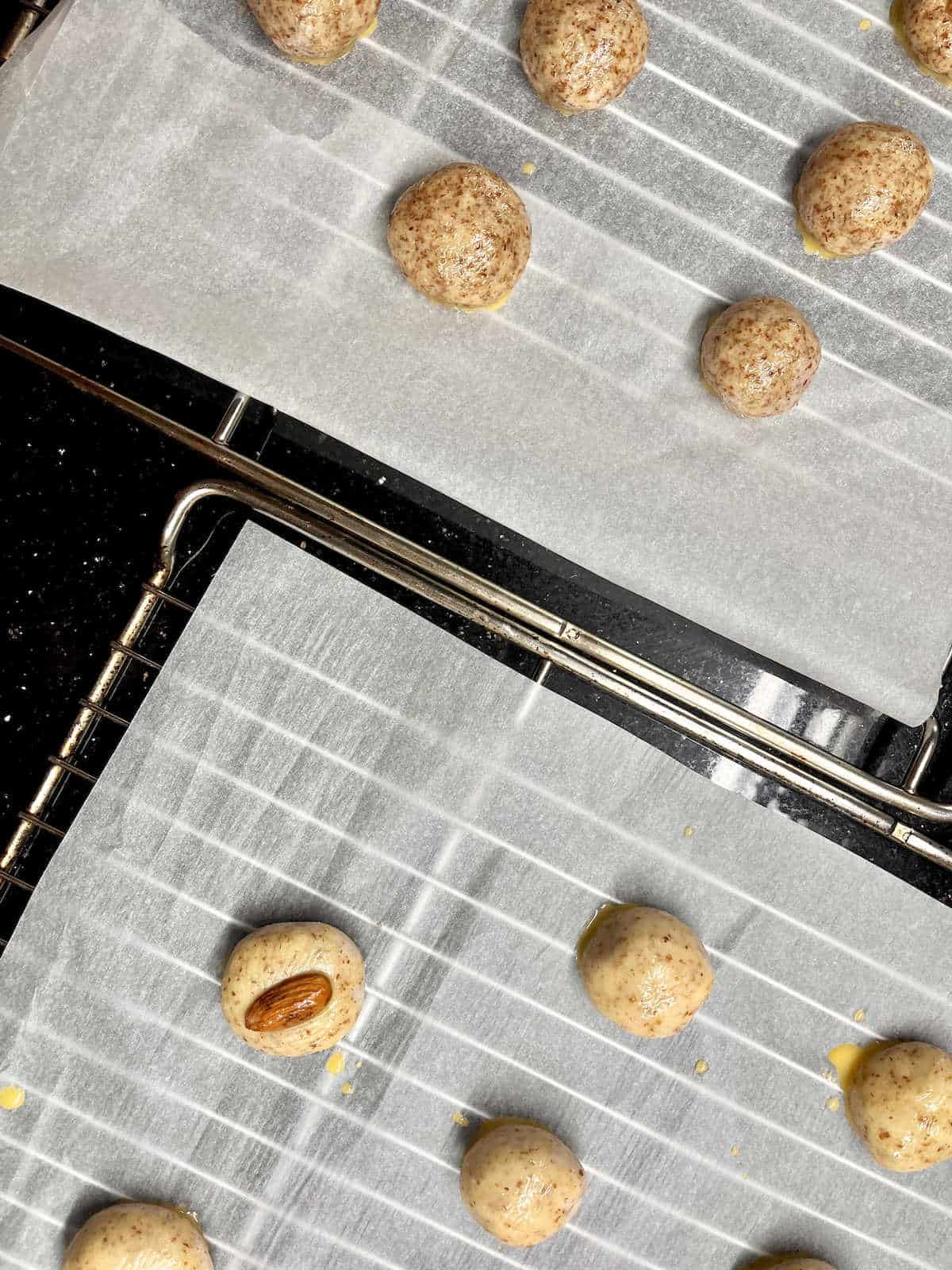 2 different types of almond cookie dough on different wire trays.