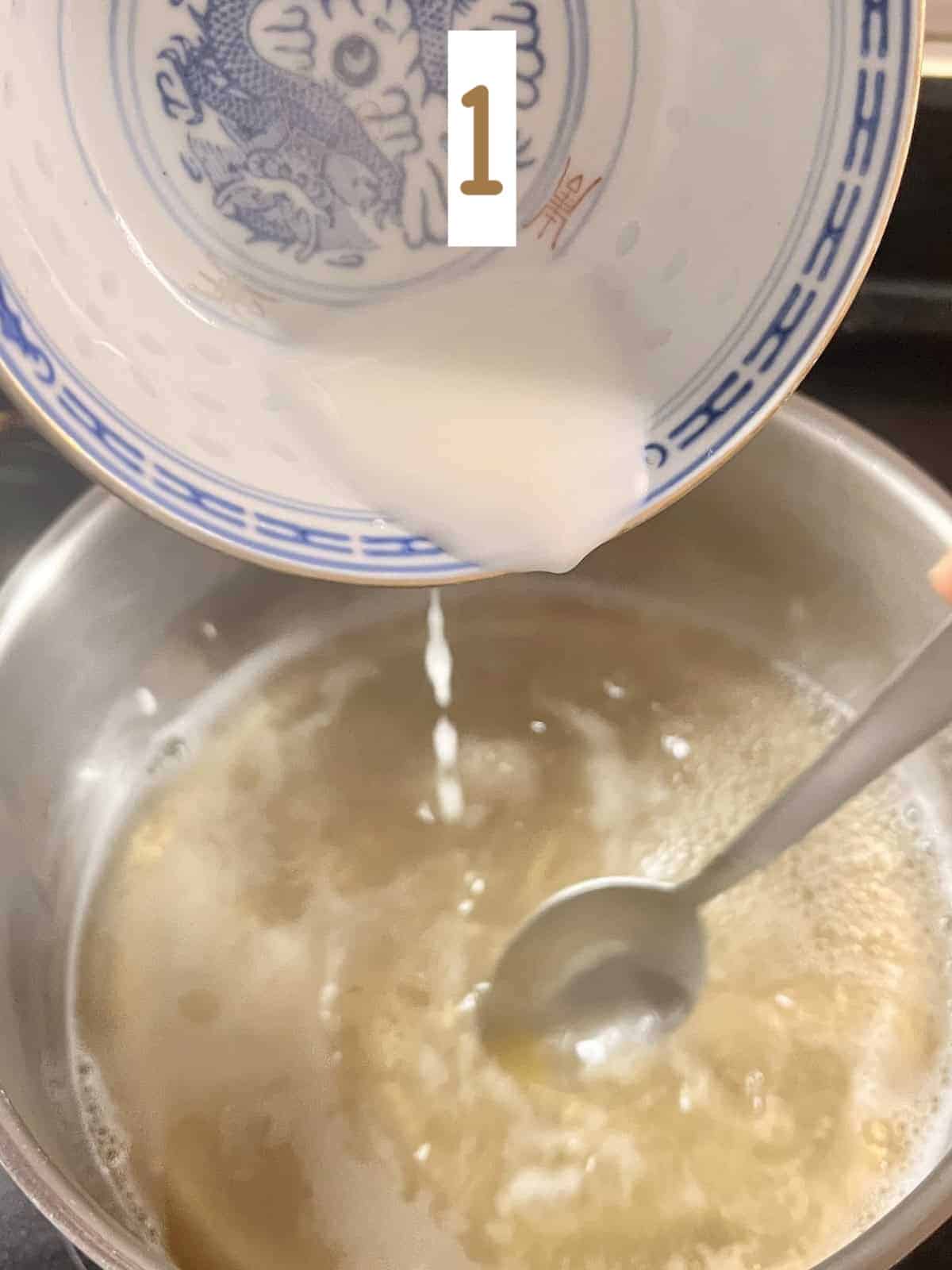 Pouring cornstarch slurry into a pot of chicken broth.