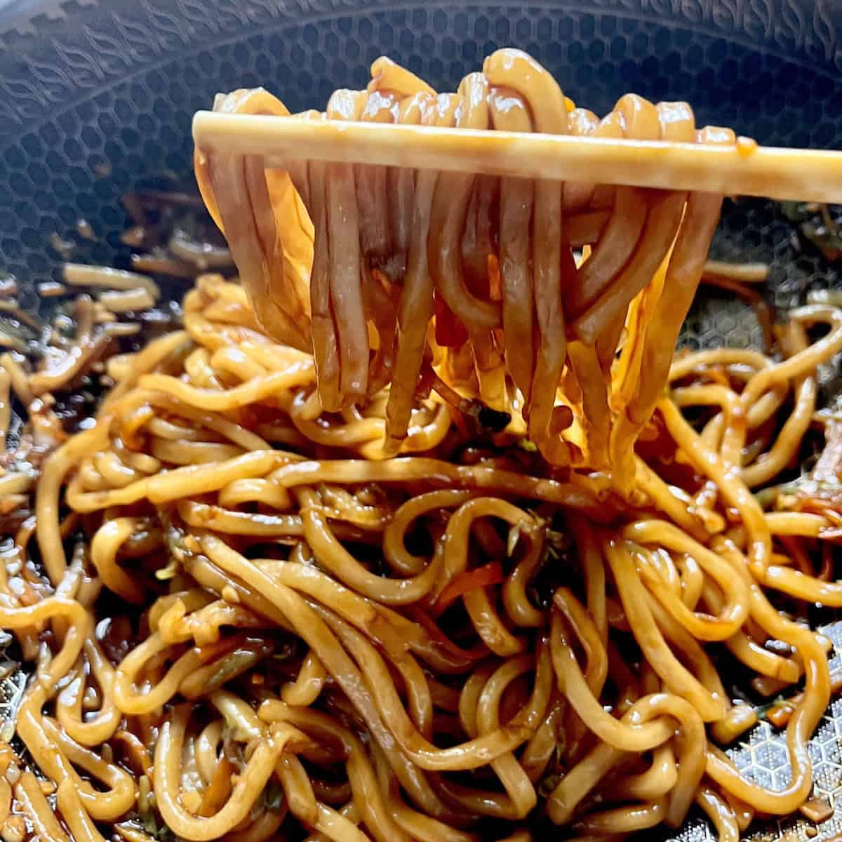 Picking up Japanese Yaki udon from a wok.