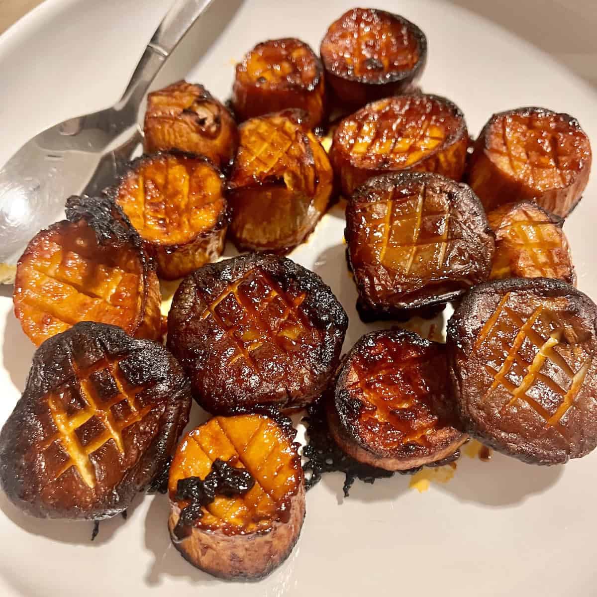 Roasted mushrooms in Korean gochujang sauce on a white plate.