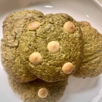 Matcha cookies with white chocolate on a white plate.