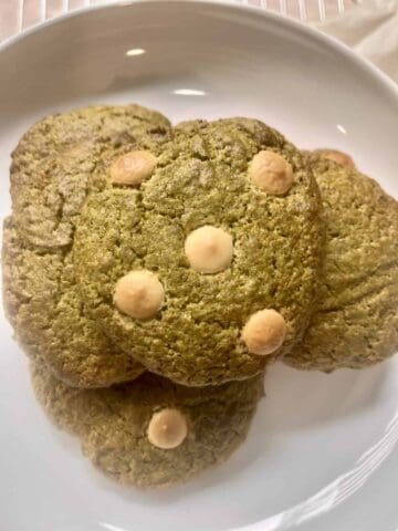 Matcha cookies with white chocolate on a white plate.