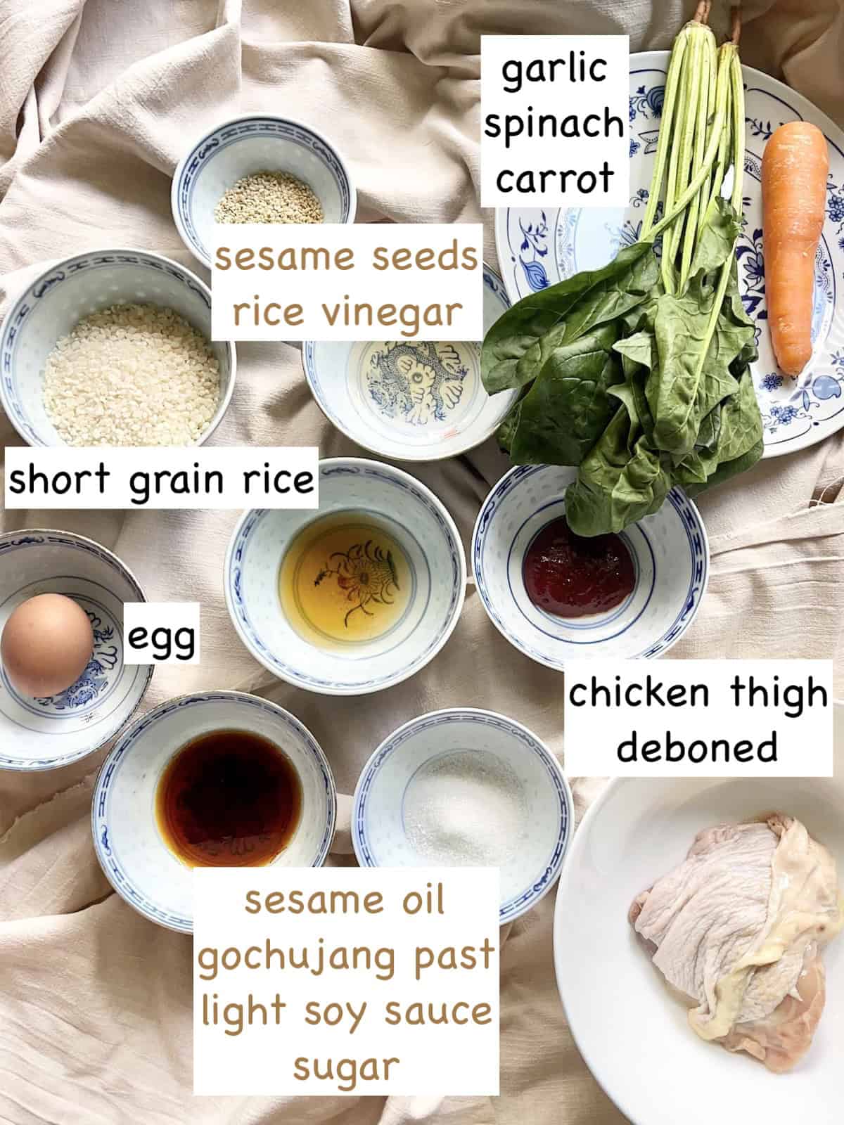 All the ingredients for chicken bibimbap on a linen cloth.