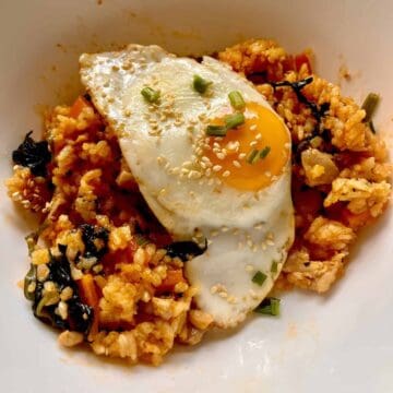 Korean bibimbap with chicken, vegetables, and fried egg.