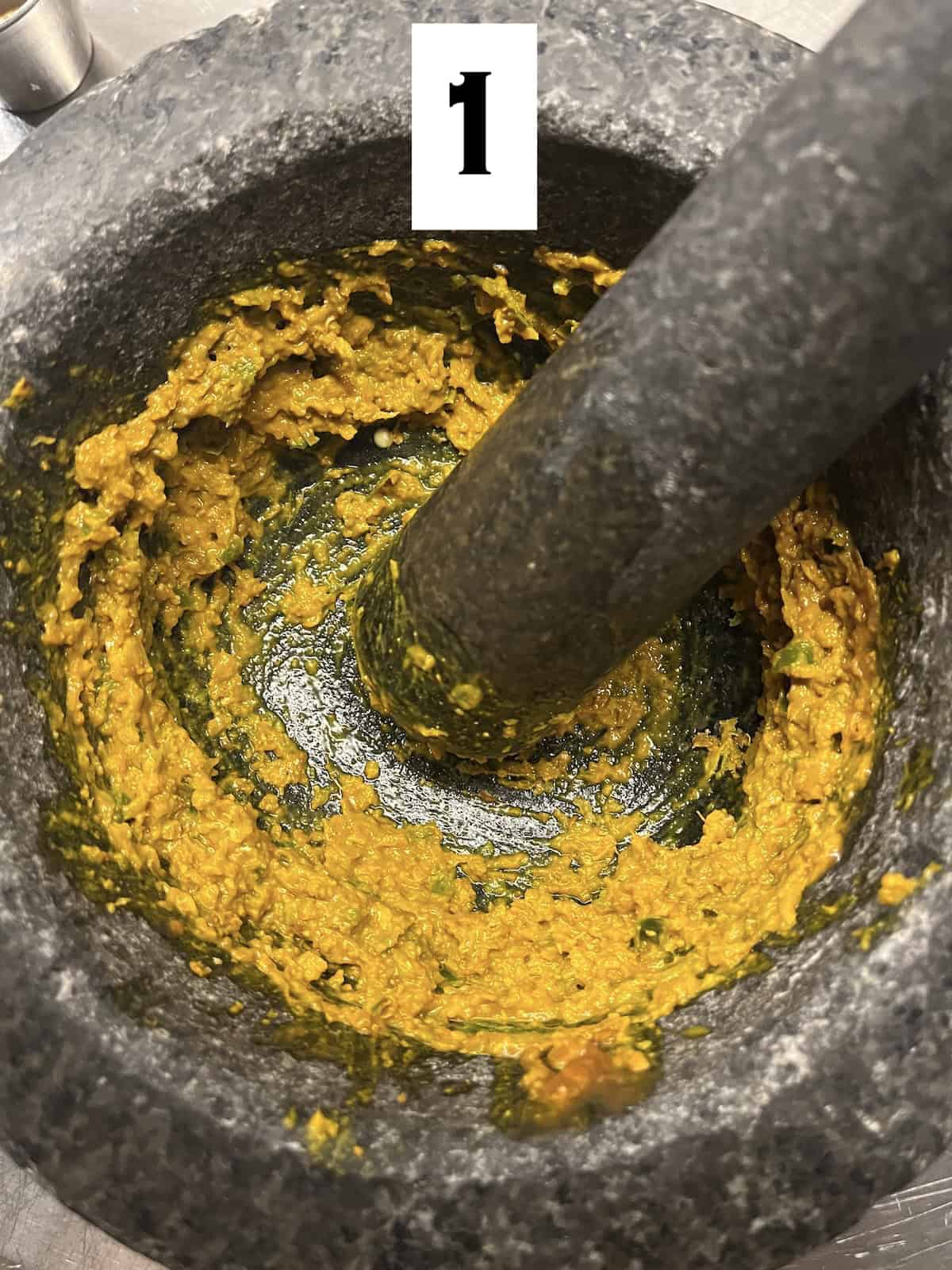 Pounding spices in a mortar and pestle.