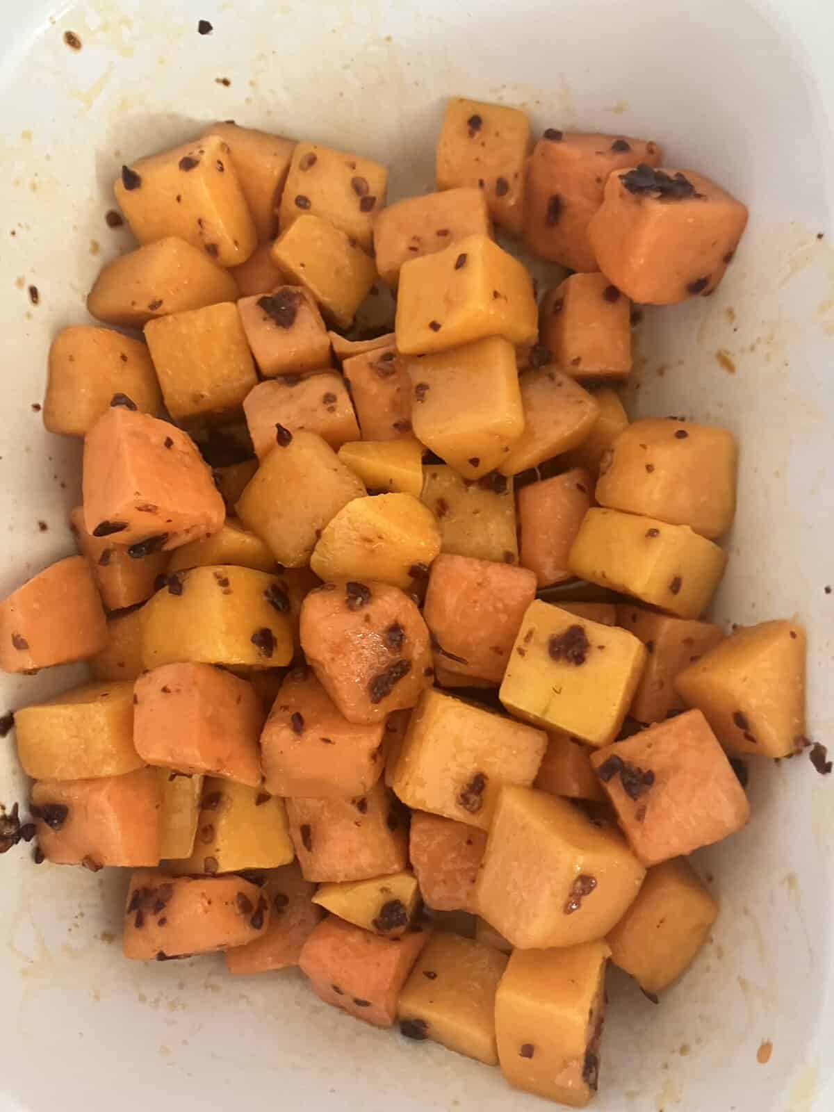 Cubed butternut squash in a roasting tin.