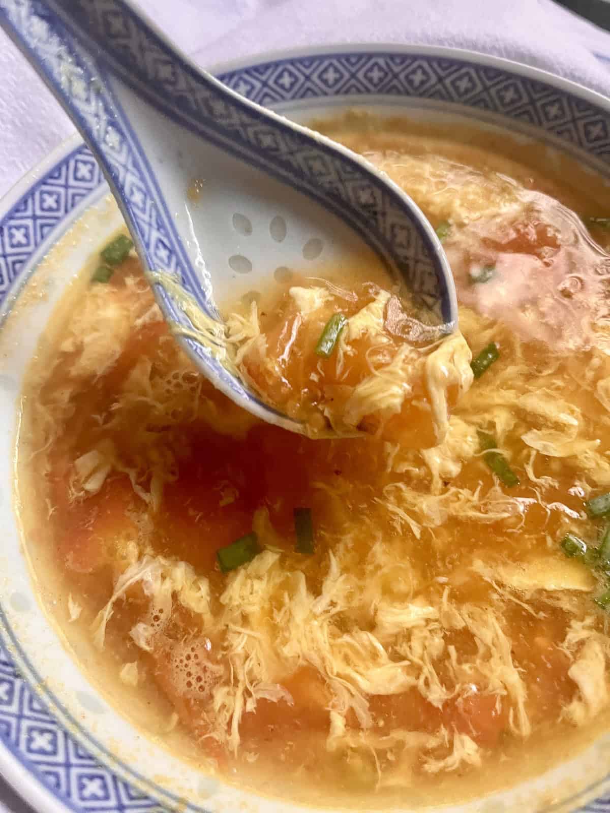 Scooping up a bowl of tomato egg drop soup.